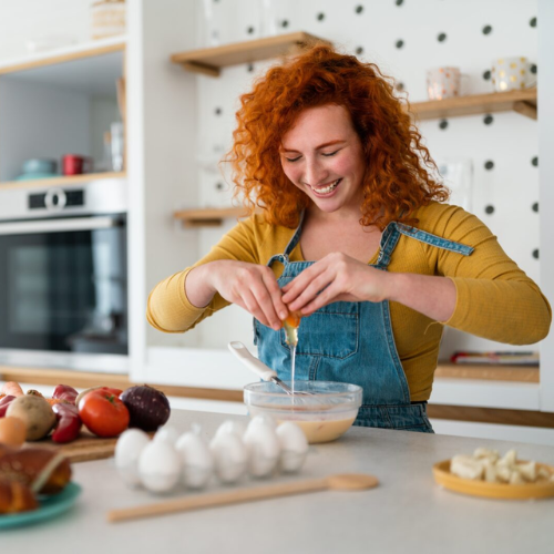 Young woman cracking eggs